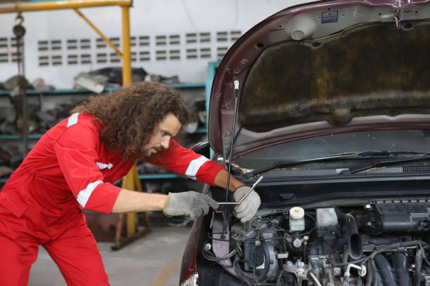 istock Auto mechanic working in garage. Repair service. Worker mechanics in uniform are working in auto service with lifted vehicle. Car repair maintenance. 1708050430