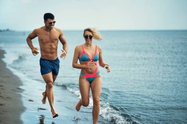 istock Young couple walking on the beach at sunset. 1708061299