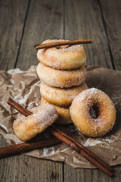 istock Sugared stacked mini donuts with cinnamon on a wooden table, vertical 1708067596