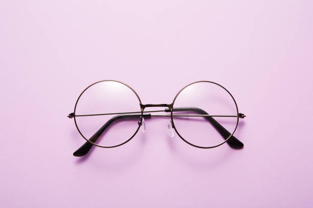 istock Glasses in round thin metal frame isolated on purple surface. 1708070913