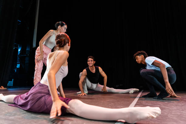 istock Young ballet dancers talking with his friend while stretching at theater 1708087102