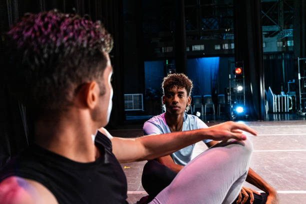 istock Young ballet dancer man talking with his friend while taking a break at stage theater 1708087647