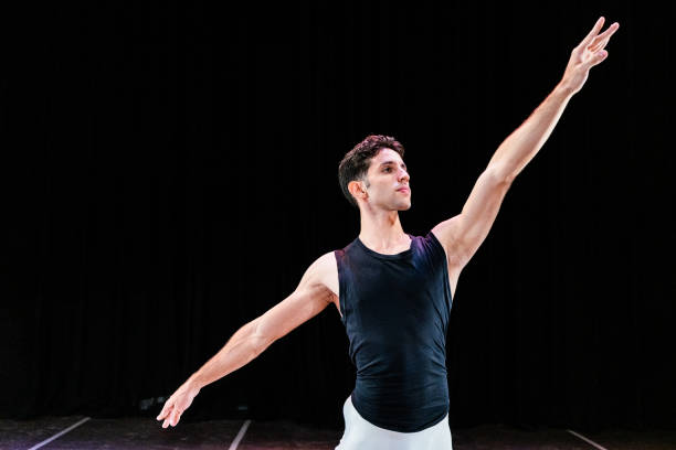 Young ballet dancer man dancing on a stage theater