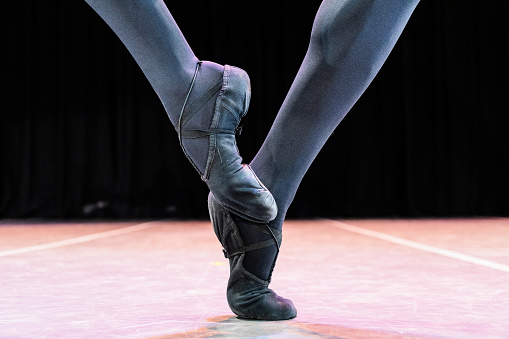 Young female ballerina standing on toes, low section