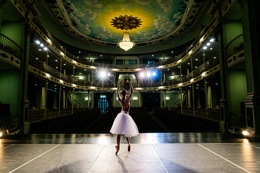 Young ballerina rehearsing on a stage theater