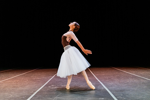 Young ballerina performing on a stage theater