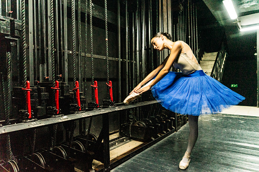 Young ballerina preparing to perform in a stage theater