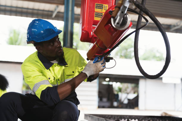 istock Industrial Robotic Arms. Automated manufacturing industries. Male engineer working and checking, repair, maintenance autonomous robotics arm for manufacturing lines at production plant factory 1708112861