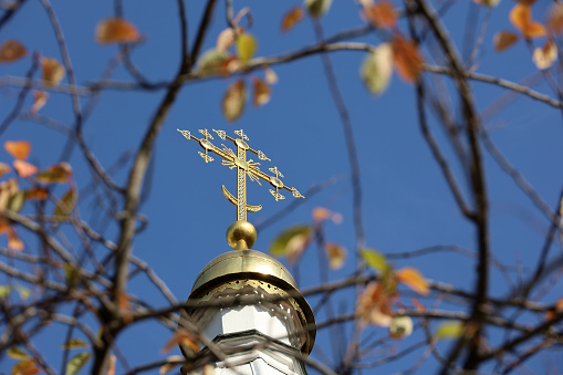 A golden Christian Cross on top of a dome