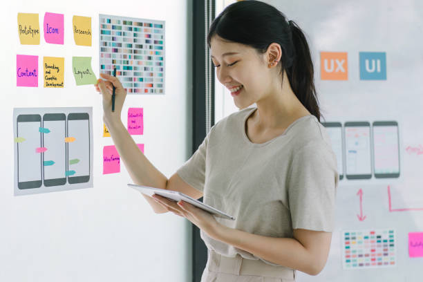 istock Creative ux designer brainstorming designing screens for mobile responsive website development with UI UX. Developing wireframe sketch layout design mockup on smartphone screen. 1708131595
