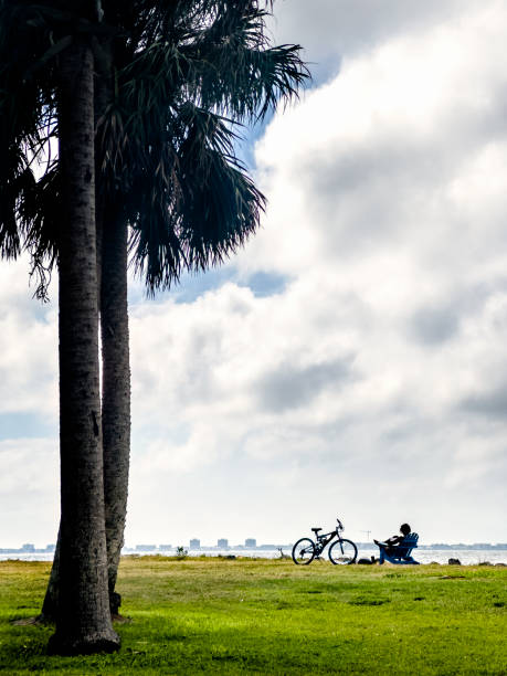 istock Young man with bicycle resting on green landscape over sky 1708160081