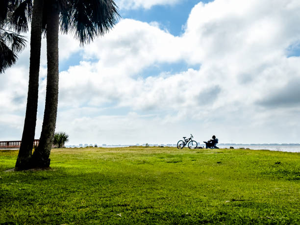 istock Young man with bicycle resting on green landscape over sky 1708160114