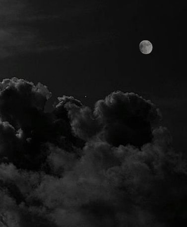 Photograph of the moon between the clouds
