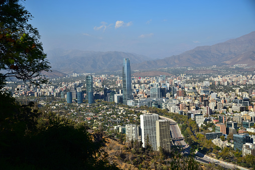 Viewed from San Cristobal Hill, South America's tallest building, the Gran Torre Santiago, is visible despite the city's smog obscuring the mountains in the background.