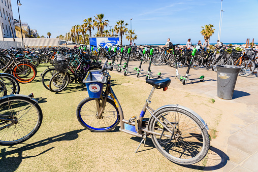Valencia, Spain - May 12, 2019: Parking lot with many rental bicycles for tourists on the Malvarrosa beach of Valencia.