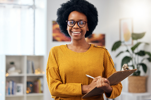 Portrait, therapist and happy black woman with checklist for counselling in office. Face smile, psychologist in glasses and clipboard for therapy session, psychology counsellor or professional doctor