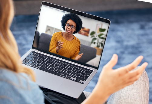 Woman, video call and psychologist on laptop screen of support, advice or helping with mental health in online meeting. African therapist talking to home client for remote therapy on computer