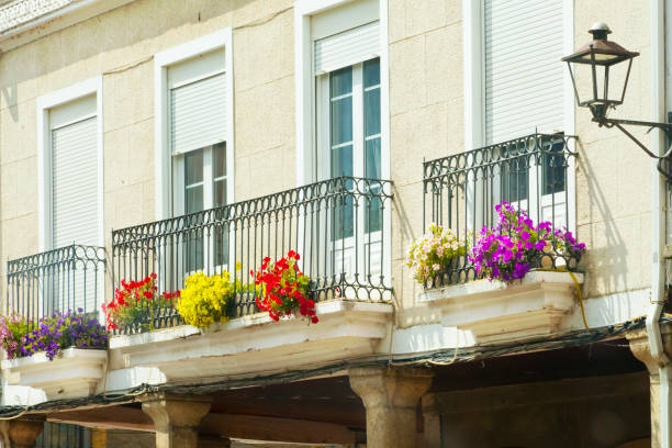 Balconies decorated with flower pots, cast iron railings, stone columns, retro style street light, Bierzo area, León province, Castilla y Leon, Spain.