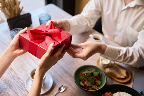 istock Top view woman making present to her man giving cute red gift box 1708261713