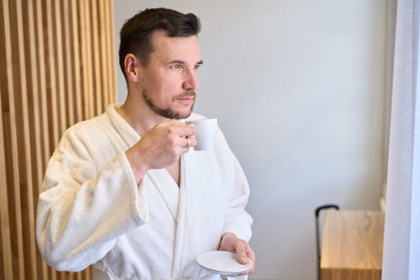 istock Bearded man in bathrobe drinking morning fresh brewed coffee 1708261768