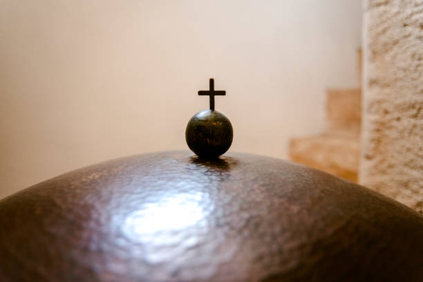 Christian cross on a small metal ball, negative space.