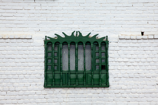 Architectural facade of an administrative building with green windows on a summer sunny day