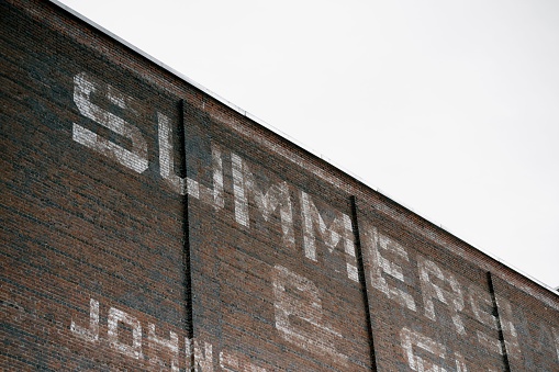 A distressed metal building with vintage lettering, with a weathered facade and a textured surface