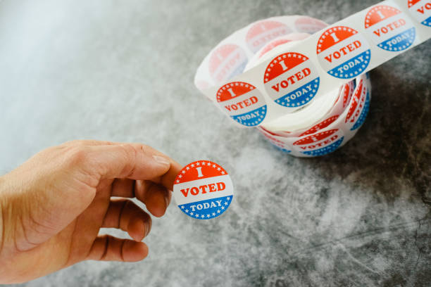 istock Man's hand teaching that he has voted today in the American elections with a sticker. 1708320532