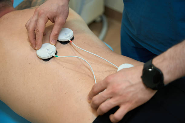 istock Healthcare professional preparing person for electromyostimulation procedure 1708341413