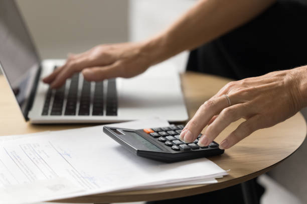 istock Hands of senior elder woman using laptop and calculator 1708363298
