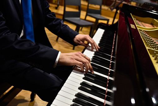 Professional pianist performing a piece on a grand piano.