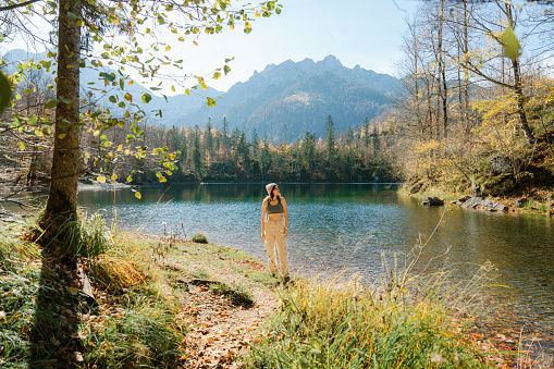 Tranquil woman walking near the lake in autumn in Tyrol, Austria