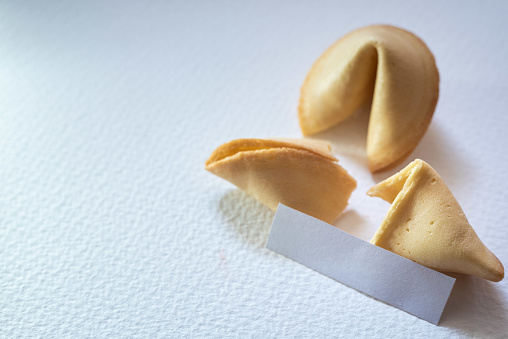 Lucky cookies broken with fortune message, isolated on white background with empty space for text.