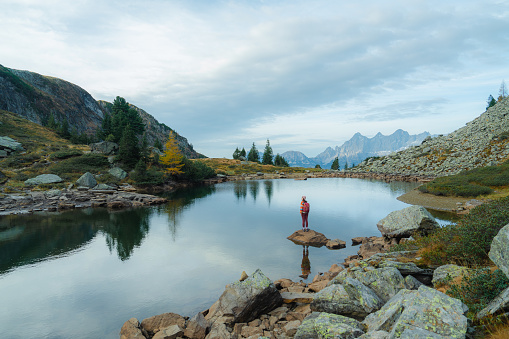 Young Caucasian woman standing on the background of Alpine lake  in Austria