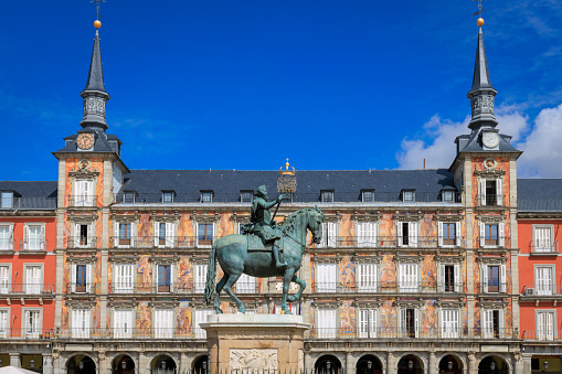 A sunny day, showing off the beautiful architecture of the Plaza Mayor building in Madrid, Spain.
