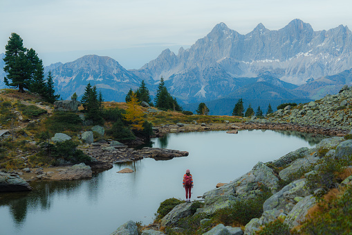 Young Caucasian woman standing on the background of Alpine lake  in Austria