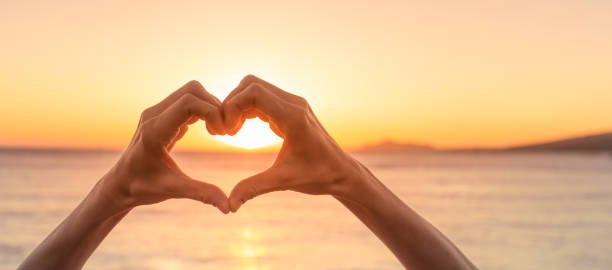istock Woman making heart symbol against a sunset. 1708404354