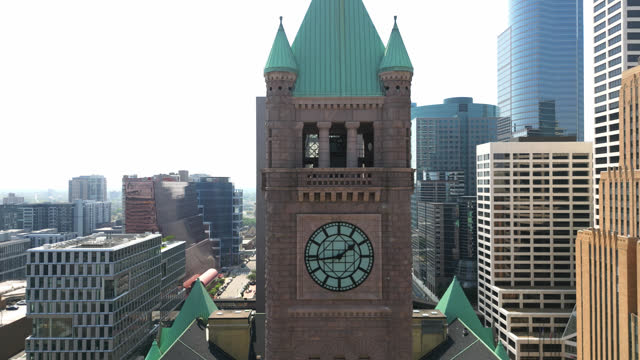 Aerial View of the Top of the Historic City Hall Clock Tower with City Buildings in the Background In Downtown Minneapolis, Minnesota, USA. Aerial Pull Back