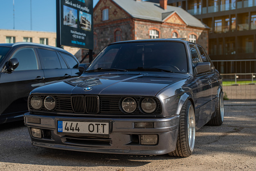 Pärnu, Estonia - September 03 2023: Dark-grey BMW 3 Series 318 E30 1985 parked in the Parnu city centre on a sunny autumn day.