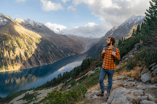 Tranquil man  hiking in European Alps surrounded by lake and mountains