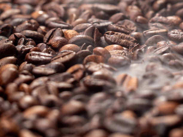 istock Close-up of roasted coffee beans with smoke. 1708451898