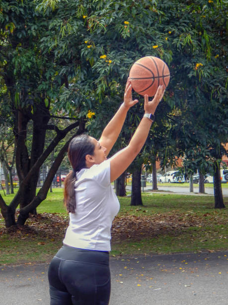 istock middle age woman playing basketball 1708453541