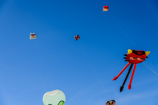Several kites of summer children's games flying in the blue sky.
