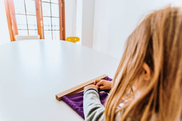 istock Girl buttoning a montessori frame to develop the dexterity of her fingers. 1708482457