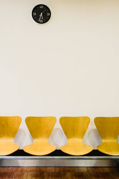 istock Waiting room with empty wooden chairs and wall clock, waiting concept. 1708491164