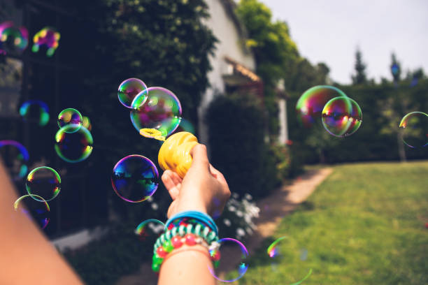 istock Child's hand holding a soap bubble while playing in summer. 1708497908
