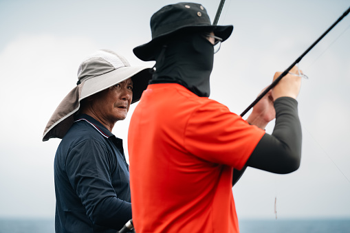 In a collaborative spirit, two fishermen exchange knowledge and share fishing techniques, fostering camaraderie and a mutual pursuit of success in their angling endeavors.