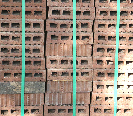 Udaipur, India - March 13, 2014: A man stands by bricks stacked, air drying, in a brick factory. Udaipur, India