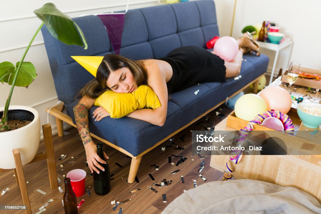 Unconscious Woman Passed Out Drunk On The Couch In A Party With A Mess