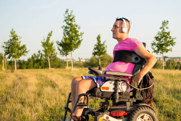 gay man in wheelchair enjoys listening to music in headphones - domestic car audio imagens e fotografias de stock
